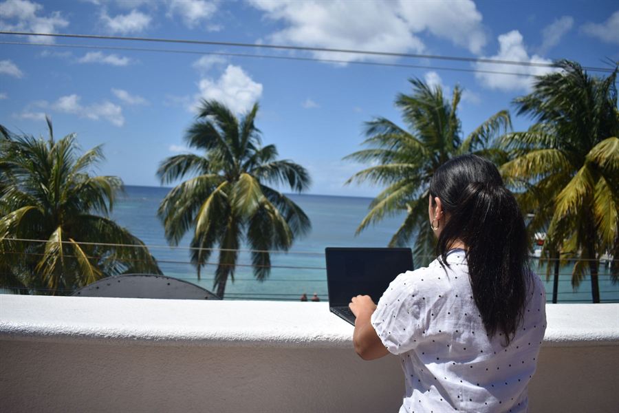 Sofia working on her laptop with an ocean view